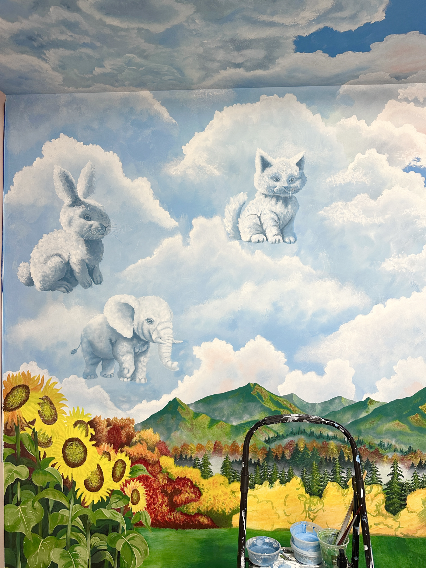 Cloud animals painted above the mountain mural